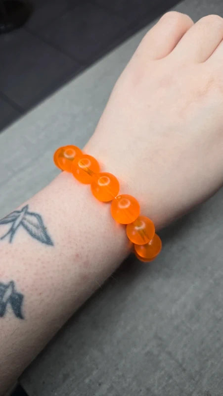 bracelet vintage - neuf - élastique - grosse perles rondes orange translucide - style rétro pop